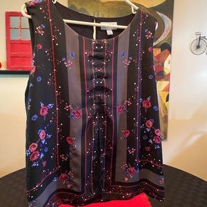 Sleeveless blouse black with small blue flowers.